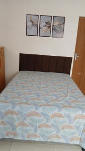 a bed in a bedroom with four pictures on the wall at ML Integra Mix kitnets in Maceió