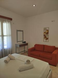 a bedroom with a bed and a red couch at Margarita's home in Nísos Skýros