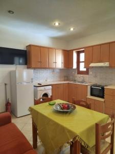 a kitchen with a table with a bowl of fruit on it at Margarita's home in Nísos Skýros +9 photos