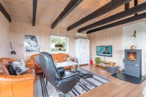 a living room with leather furniture and a fireplace at 319-Hvide-Sande-Gammeleng-16 in Hvide Sande