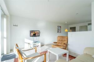 a living room with a couch and chairs and a tv at 769-Hvide-Sande-Norregade-4-C in Hvide Sande