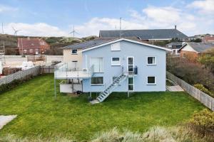 a blue house with a staircase in a yard at 769-Hvide-Sande-Norregade-4-C in Hvide Sande +17 photos