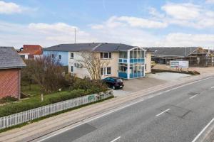 a house with a car parked next to a street at 769-Hvide-Sande-Norregade-4-C in Hvide Sande