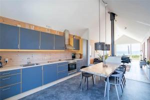a kitchen with blue cabinets and a table with chairs at 753-Hvide-Sande-Slusen-53 in Hvide Sande