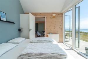 a bedroom with a large bed and large windows at 753-Hvide-Sande-Slusen-53 in Hvide Sande