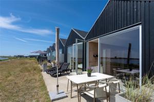 a house on the beach with a white table and chairs at 753-Hvide-Sande-Slusen-53 in Hvide Sande
