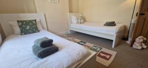 a bedroom with two beds with towels on them at Windsor Castle amazing Cottage in Windsor