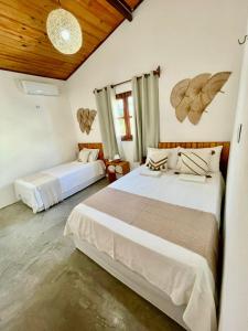 a bedroom with two beds and a wooden ceiling at Casa Ariacó in Amontada