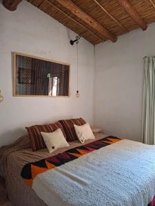 a bedroom with a large bed with two pillows at Cactus y Almacen - Purmamarca in Purmamarca