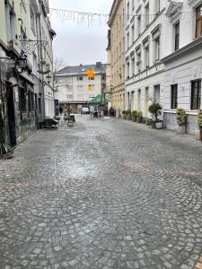 a cobblestone street in a city with buildings at Haus zum Bacchus Privatezimmer near Bahnhof Römisches Theater Mainz in Mainz
