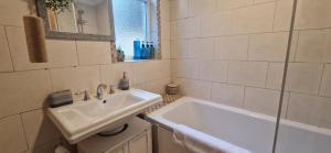 a white bathroom with a sink and a mirror at Windsor Castle amazing Cottage in Windsor
