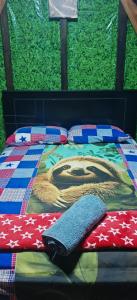 a bed with a blanket and pillows on it at Casa Perezosa in Parrita +11 photos