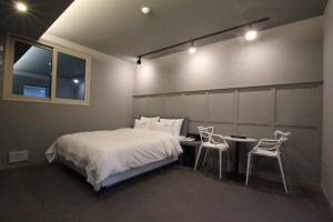 a bedroom with a bed and a table and two chairs at Novahotel in Samgong +5 photos