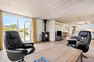 a living room with two chairs and a fireplace at 355-Hvide-Sande-Fyrmarken-54 in Hvide Sande