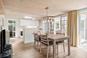 a kitchen and dining room with a table and chairs at 355-Hvide-Sande-Fyrmarken-54 in Hvide Sande
