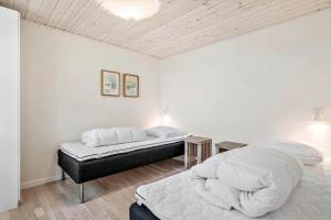 a bedroom with a large bed and a table at 355-Hvide-Sande-Fyrmarken-54 in Hvide Sande
