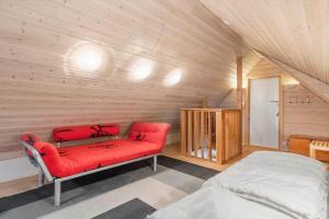 a room with a red couch in a wooden room at 5537-Hvide-Sande-Vesterledvej-14 in Havrvig