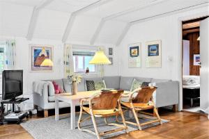 a living room with a couch and a table and chairs at 602-Hvide-Sande-Nygardsvej-32 in Bjerregård +21 photos