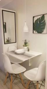 a white dining room table with white chairs and a mirror at Sunvida tower Unit 1911 in front Sm Cebu in Cebu City