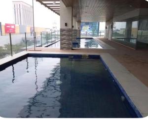 a large swimming pool in a building with water at Sunvida tower Unit 1911 in front Sm Cebu in Cebu City
