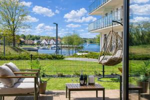a patio with a hammock and a view of the water at ApartView - ogród, taras, winda, widok na Jeziorak, Netflix i Max, parking in Iława +26 photos