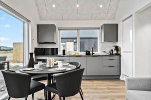 a kitchen and dining room with a table and chairs at 9951-Hvide-Sande-Langsand-206 in Hvide Sande +33 photos