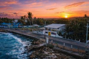 a sunset over a beach with a pier and the ocean at Inn Skyline Hostel in San Andrés
