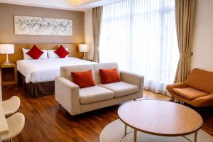 a hotel room with a bed and a couch and a table at Cormar Residences Kuala Lumpur in Kuala Lumpur
