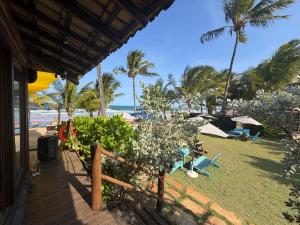 a view of a beach with chairs and palm trees at Vila BeiradeiRô - Taipu de Fora in Taipu