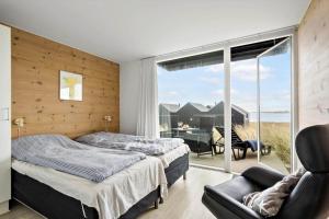 a bedroom with a bed and a sliding glass door at 719-Hvide-Sande-Slusen-19 in Hvide Sande