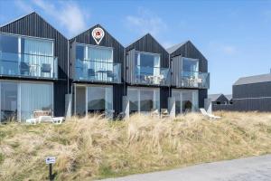 a black house on top of a hill at 719-Hvide-Sande-Slusen-19 in Hvide Sande