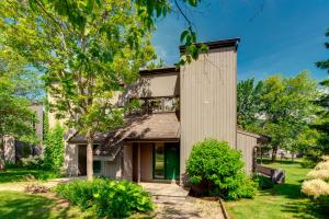 a house with a green door and trees at D-Chalet - 9 personnes - 2 chambres in Beaupré