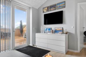 a living room with a tv and a white dresser at 776-Hvide-Sande-Norregade-2-nr-27 in Hvide Sande
