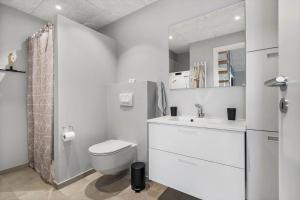a white bathroom with a toilet and a sink at 776-Hvide-Sande-Norregade-2-nr-27 in Hvide Sande +23 photos