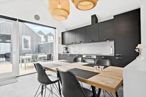 a kitchen and dining room with a wooden table and chairs at 707-Hvide-Sande-Slusen-7 in Hvide Sande