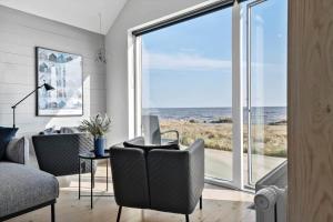 a living room with a desk with a computer and a view of the ocean at 707-Hvide-Sande-Slusen-7 in Hvide Sande