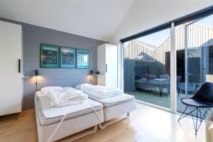 a bedroom with a bed and a balcony with a table at 707-Hvide-Sande-Slusen-7 in Hvide Sande