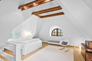 a white bedroom with a white bed and a window at 5507-Hvide-Sande-Tornbjerrevej-56 in Havrvig