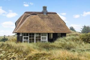an old house with a thatched roof in a field at 5507-Hvide-Sande-Tornbjerrevej-56 in Havrvig
