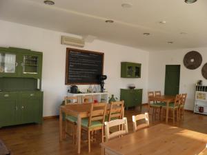 a kitchen with green cabinets and wooden tables and chairs at Monte de Portugal in Montargil