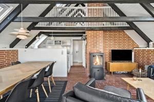 a living room with a fireplace and a table and chairs at 311-Hvide-Sande-Fyrmarken-7 in Hvide Sande