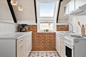 a kitchen with white appliances and a brick wall at 311-Hvide-Sande-Fyrmarken-7 in Hvide Sande +30 photos