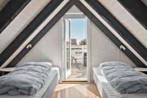 a room with two beds in a room with a window at 311-Hvide-Sande-Fyrmarken-7 in Hvide Sande
