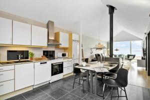 a kitchen with white cabinets and a table and chairs at 703-Hvide-Sande-Slusen-3 in Hvide Sande