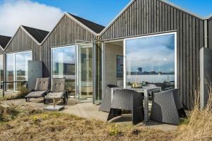 a house with a patio with a table and chairs at 703-Hvide-Sande-Slusen-3 in Hvide Sande