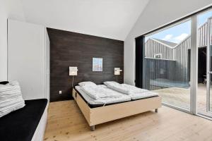 a bedroom with a bed and a large window at 703-Hvide-Sande-Slusen-3 in Hvide Sande