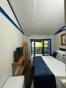 a bedroom with a bed and a balcony with a window at Pousada Dom Luiz in Ouro Preto
