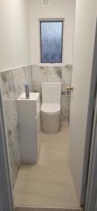 a bathroom with a toilet and a window at Paradise on Snells Beach in Snells Beach