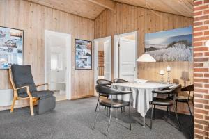 a dining room with a table and chairs at 513-Hvide-Sande-Riskrogvej-16 in Havrvig