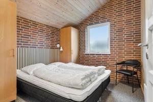 a bedroom with a bed in a brick wall at 513-Hvide-Sande-Riskrogvej-16 in Havrvig